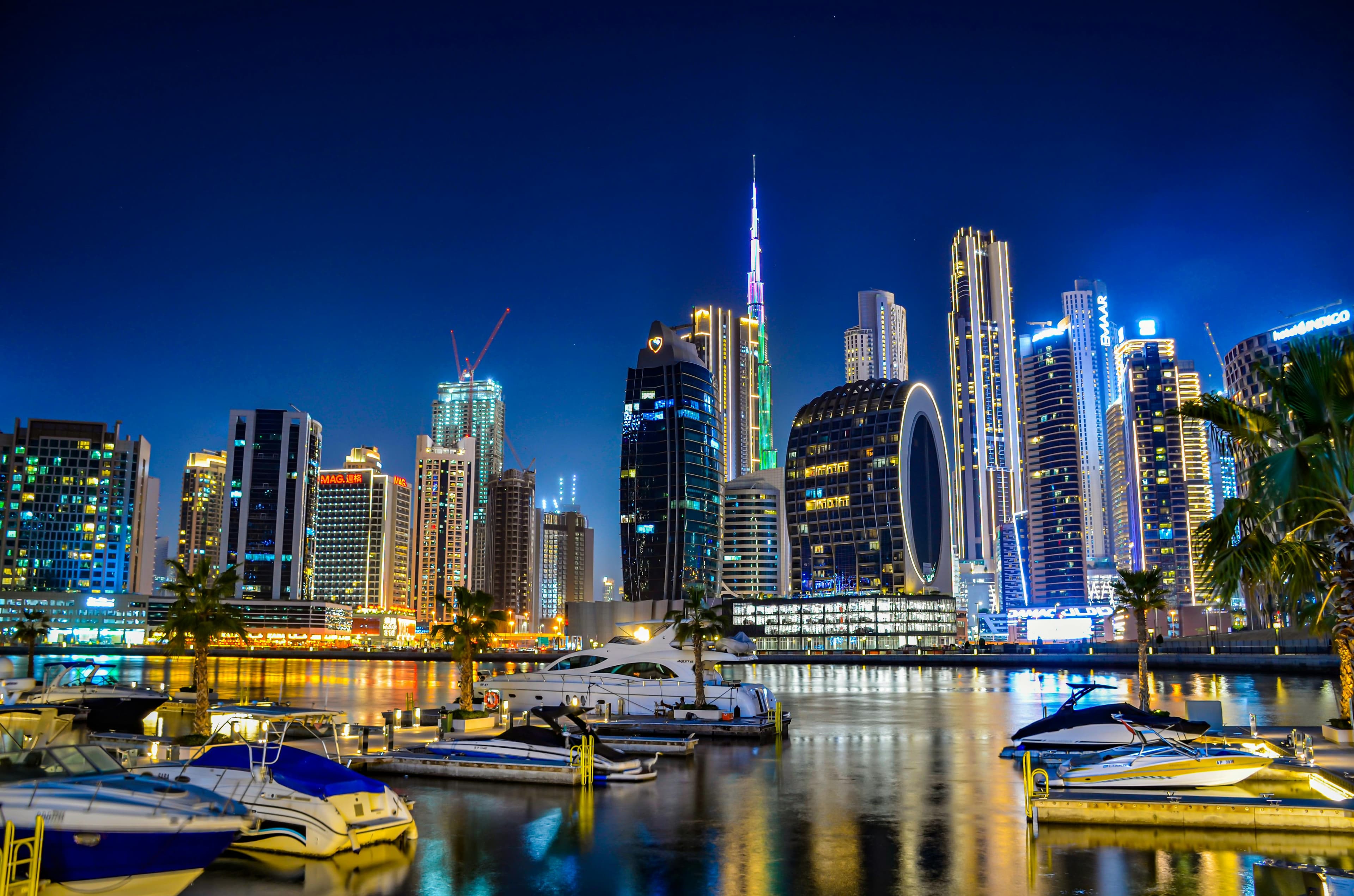 A luxurious yacht sailing on the water with a city skyline in the background.